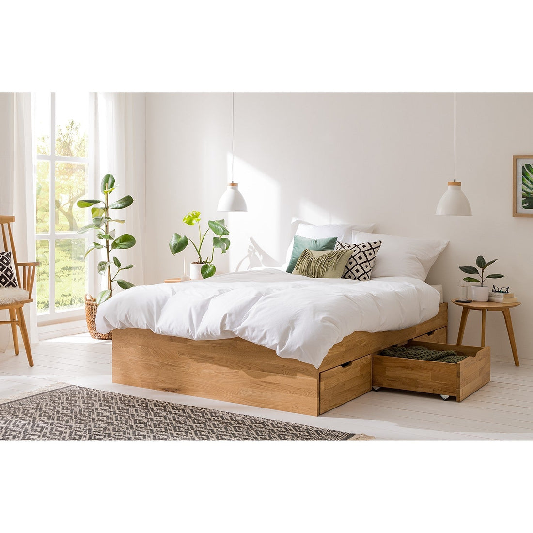 Cama de carvalho maciço com gavetas de arrumação num quarto minimalista e luminoso.