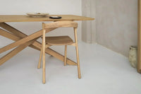 Mesa de madeira maciça numa sala de jantar moderna com luz natural