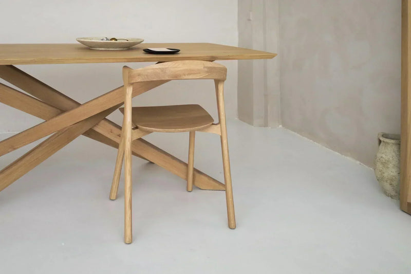 Mesa de madeira maciça numa sala de jantar moderna com luz natural